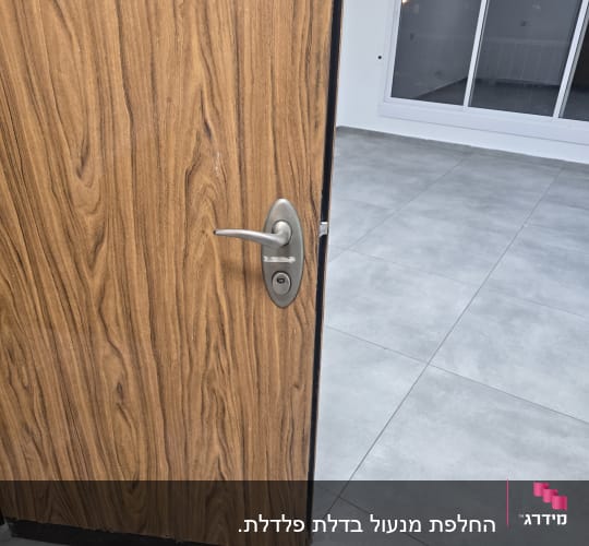 דלת עץ פתוחה עם ידית ומנעול מתכת
